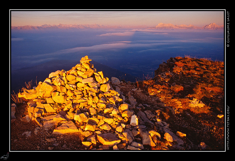 Mont Aiguille : Le cairn sommital du Mont Aiguille au soleil couchant, avec l'ombre du sommet sur les brumes qui 
recouvrent le Trièves